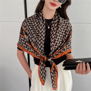 Dettaglio di un foulard di lusso in seta con stampa vintage ed elegante bordo arancione