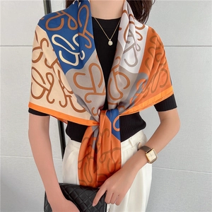 Dettaglio di un foulard di seta come scialle con motivi dorati in blu e arancio