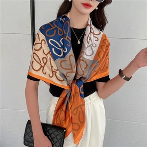 Dettaglio del motivo di un grande foulard di seta quadrato con stampa di lettere lusso