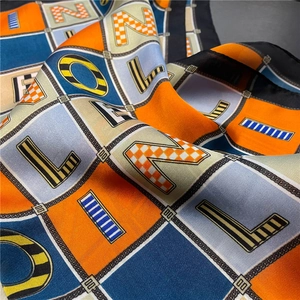 Detailed view of colorful letter print silk scarf with chain border and rolled edges
