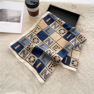 Detailed pattern of colorful letter square silk scarf on a stylish tray