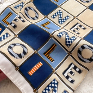 Detail of color-block letter pattern on 70cm silk scarf with geometric chain texture