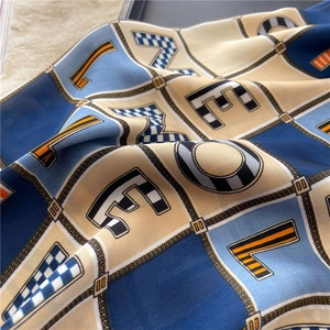 Macro shot of silk-like scarf showing colorful LOVE letters and geometric plaid patterns