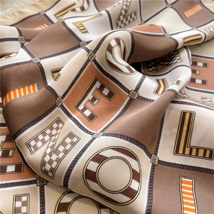 Detailed close-up showing silk-like fabric texture and chain print on square scarf