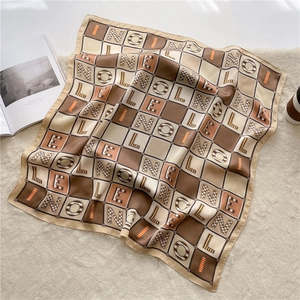 Detail of checkered silk scarf with artistic letters on a minimalist soft rug