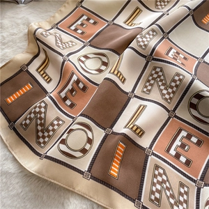 Detail of colorful letter printed silk scarf with chain pattern and checkerboard design