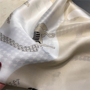 Close-up of silk scarf with equestrian horse prints and houndstooth pattern detail