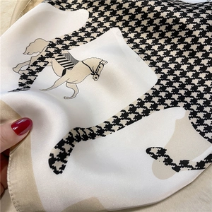 Close-up of houndstooth silk scarf with vintage horse print and smooth satin texture