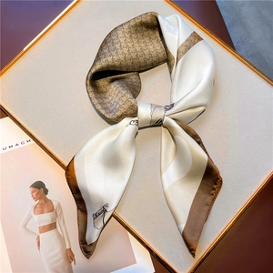 Detailed close-up of silk square scarf featuring houndstooth pattern and profile sketches