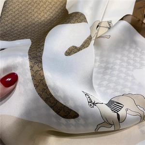 Macro detail of silk-like satin fabric with houndstooth patterns and horse motifs