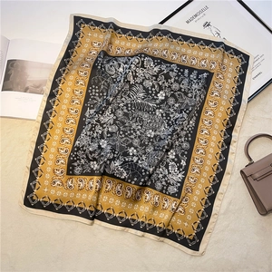 Détail d'un foulard en soie vintage aux motifs paisley avec accessoires de luxe