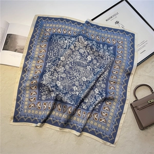 Détails du motif d'un carré en soie bleu marine avec imprimés paisley et motifs floraux