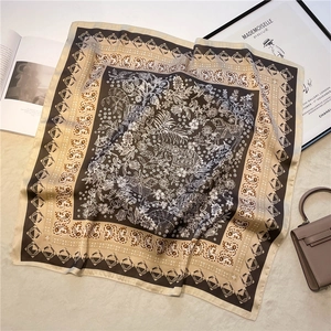 Détail d'un foulard carré vintage avec bordure paisley, imprimé éléphant et texture soie