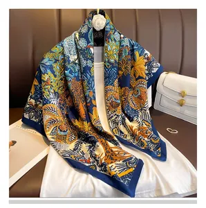 Détail d'un foulard en soie avec des motifs tropicaux jaunes sur fond bleu foncé