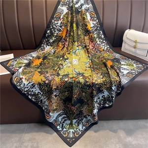 Élégant foulard en soie de 90 cm avec imprimé jungle et fleurs sur un canapé en cuir