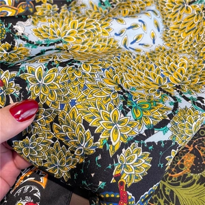 Gros plan sur le tissage sergé d'un foulard en soie aux motifs dorés et bleus
