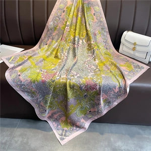 Détail d'un foulard en soie à imprimé floral et oiseaux avec bordure rose sur cuir