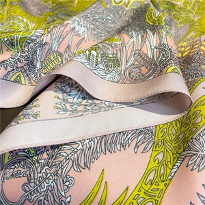 Gros plan sur l'imprimé cachemire tropical du foulard rose effet soie à maille sergé