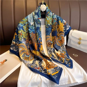Détail de l'imprimé floral bohème sur foulard en soie marine avec sac à main de luxe