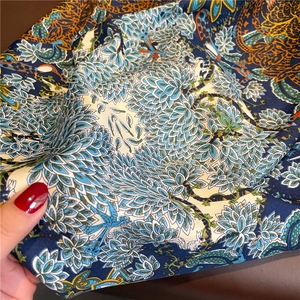 Gros plan d'un foulard en soie aux motifs floraux et à la texture satinée lisse