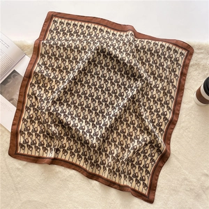Close-up of luxury 70cm silk-like scarf with equestrian stirrup and chain patterns