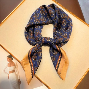 Detail view of luxury horse-bit chain printed satin silk scarf in navy and orange