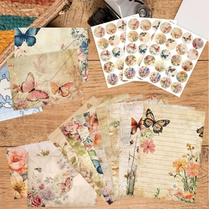 Vintage Briefpapier Set mit Blumen und Schmetterlingsmotiven auf einem rustikalen Holztisch