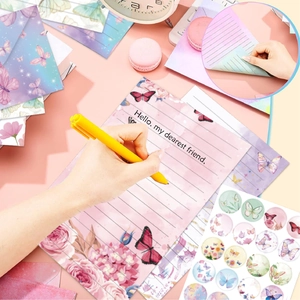 Macro detail of watercolor floral stationery set with pink rose patterns and round stickers