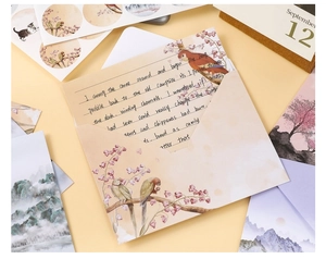 Detail view of vintage stationery set with floral bird illustrations and landscape postcards
