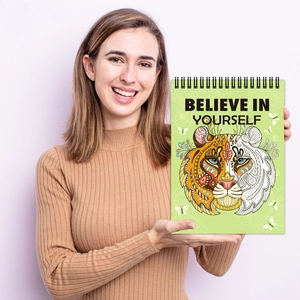 Spiral coloring book with tiger mandala cover and Believe in Yourself text held by model