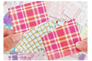 Detailaufnahme von handgerissenem rosa-gelbem Gitter-Washi-Papier für Scrapbooking