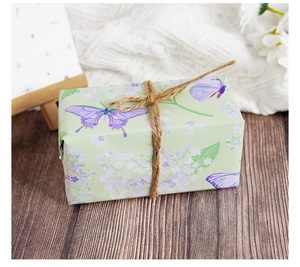 Detail einer Geschenkbox mit Blumenmuster, Schmetterlingen und rustikalem Hanfseil
