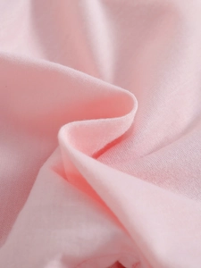 Close-up of pink combed cotton fabric for girl's dress showing soft knit texture