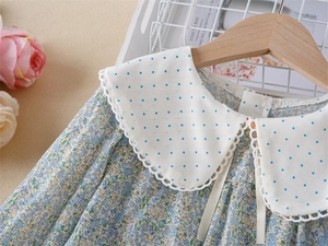 Détail d'une robe fleurie pour fille avec col Claudine, dentelle et pois bleus