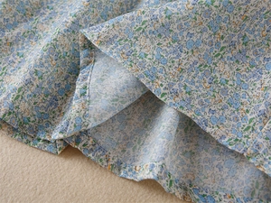 Détail de l'imprimé floral marguerite sur robe fille avec couture d'ourlet soignée