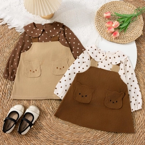 Detail von Polka-Dot-Shirt und Cord-Trägerkleid mit süßer Bär-Tasche für Mädchen