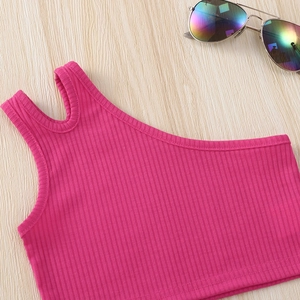 Close-up of pink ribbed knit one-shoulder crop top for girls on light wood background