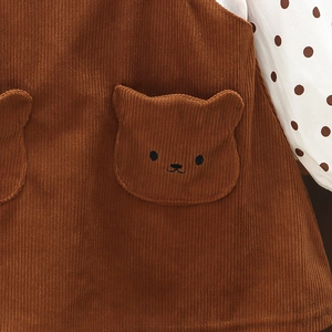 Detail von Baby-Cord-Trägerkleid mit süßer Bärtasche und Polka-Dot-Ärmeln