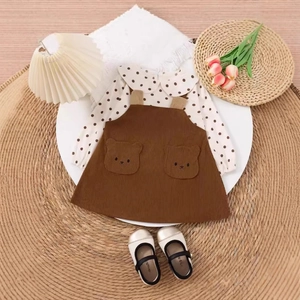 Flachbild von Mädchen-Polka-Dot-Oberteil und braunem Cord-Trägerkleid mit Bärtaschen