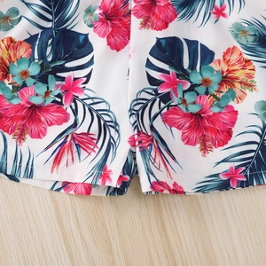Detail shot of girls summer shorts featuring tropical hibiscus flowers and palm leaves print
