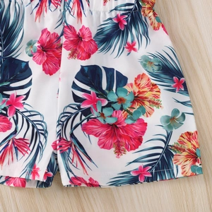 Close-up of tropical floral print on kids shorts with hibiscus flowers and palm leaves