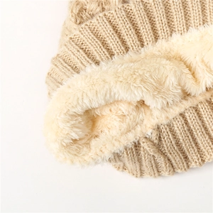 Detail of warm winter knit hat showing thick beige corduroy texture and plush fleece lining