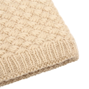Macro detail of beige basket weave knit scarf showing thick ribbed edge and soft texture