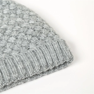 Detail shot of light grey knit winter beanie showing premium wool texture and honeycomb patterns