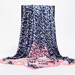 Detail of silk-satin scarf showing geometric letter prints and contrast pink border