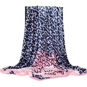 Navy and pink geometric letter print satin silk scarf hanging on a black display stand