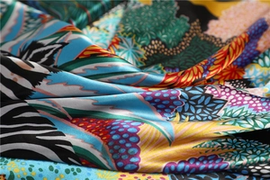 Detail of vibrant silk scarf showing tropical floral prints and smooth satin texture