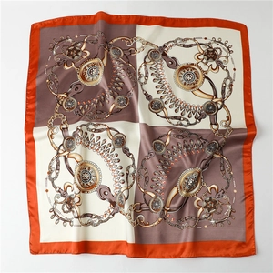 Detail view of square silk scarf with vintage orange chain pattern and rolled edges