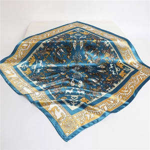 Détail du foulard carré en soie avec motifs floraux et animaux bleu marine et doré élégant