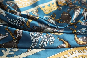 Gros plan sur une écharpe en soie aux motifs de paon et fleurs, fini brillant